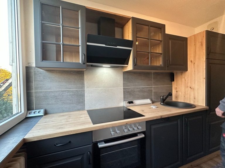 Moderne Einbauküche mit dunklen Fronten und Holzarbeitsplatte - 3-Zimmer-Wohnung in Bad Salzuflen.